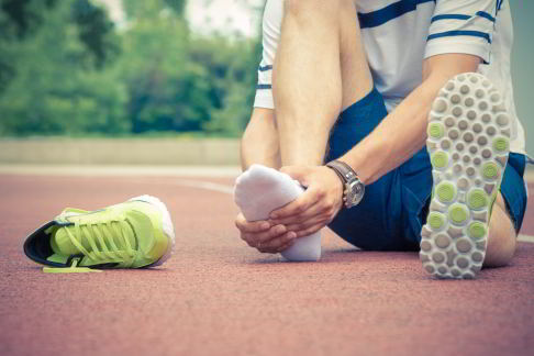 Un homme souffrant d’une douleur au pied lors de l’activité sportive.